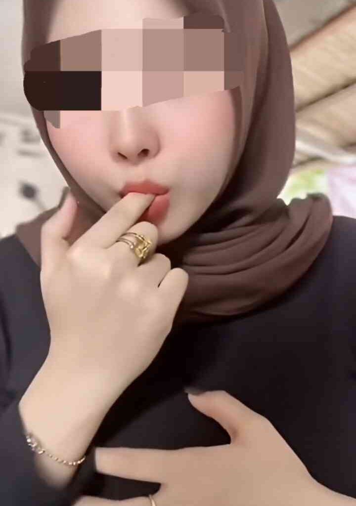 Charming 22yo Malay woman with hijab and makeup, touching lips