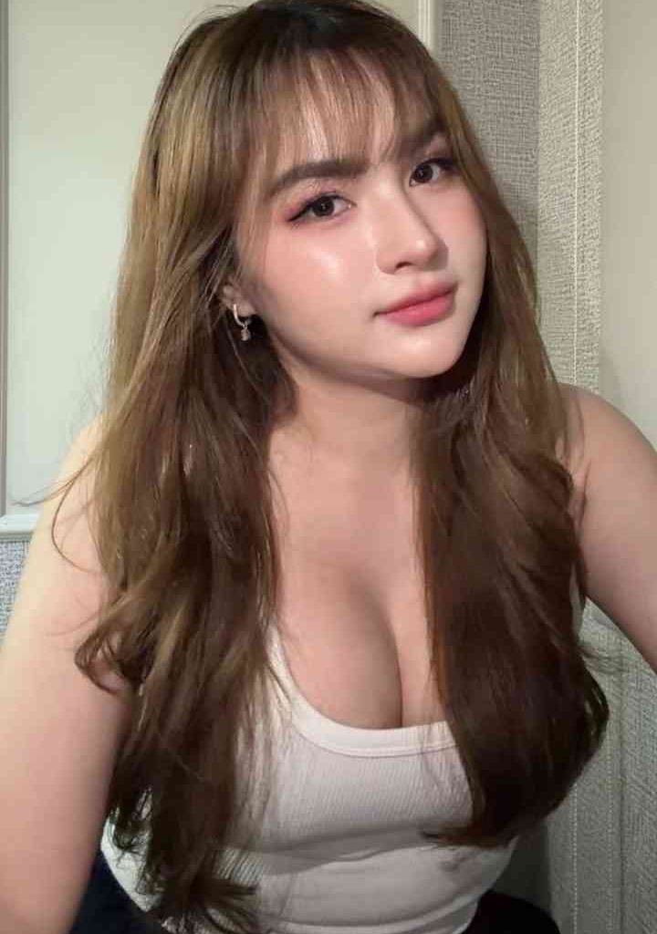Isya, 23yo slim Malay escort in KL, wearing a white tank top.