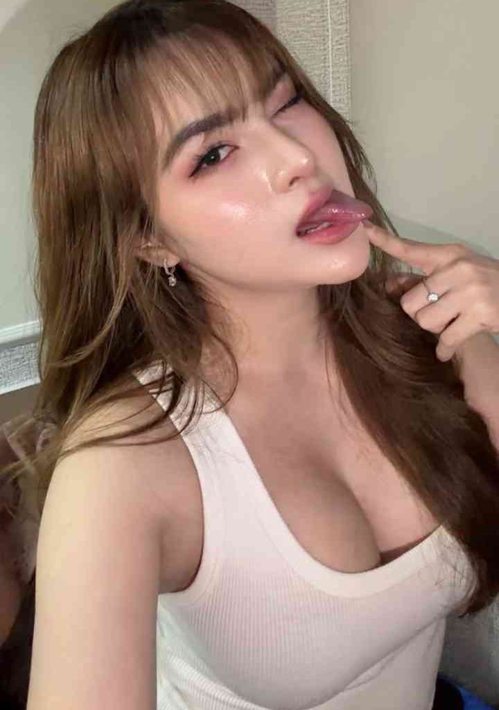Isya, 23yo slim Malay escort in KL, winks and sticks out tongue.